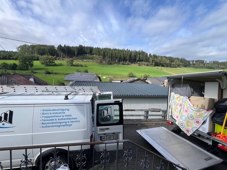 Commercial delivery van parked at industrial facility with solar panels and green countryside in background